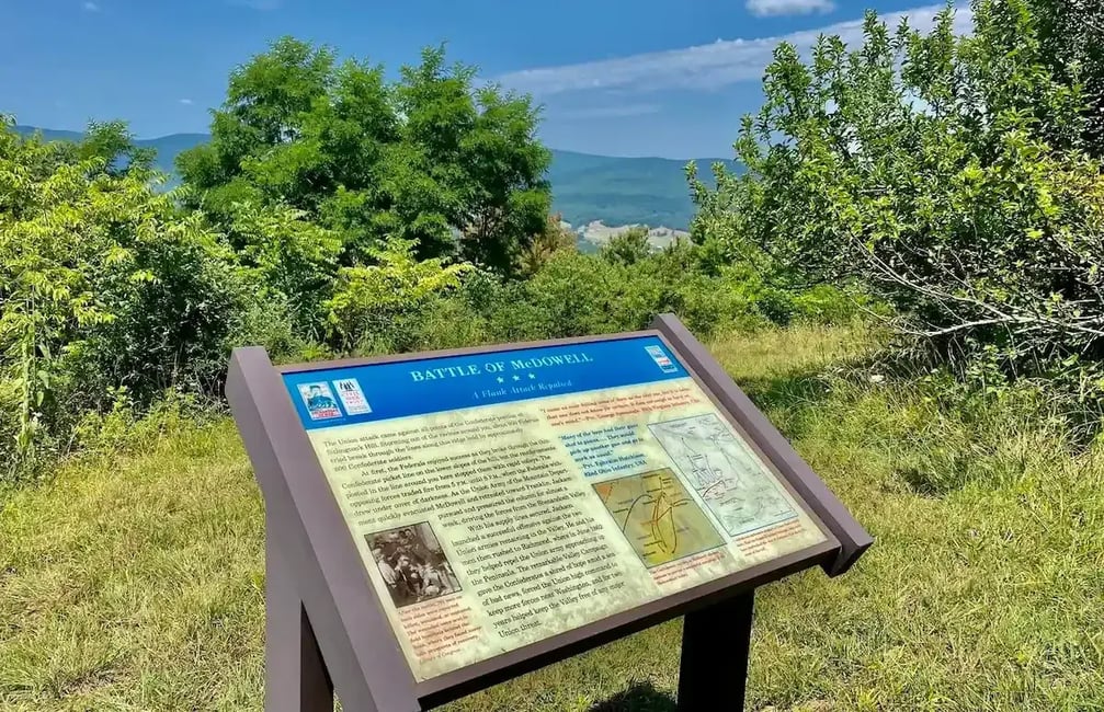 A wooden sign with information about the Battle of McDowell