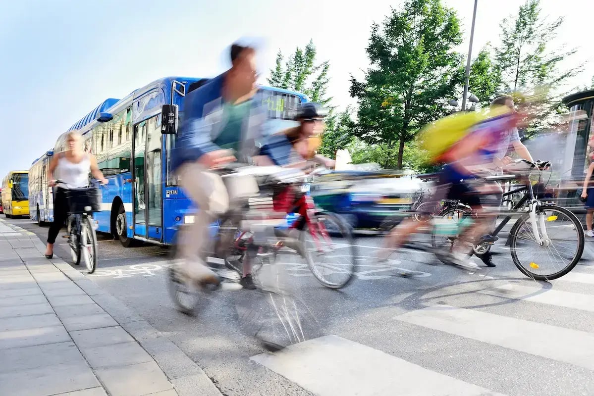 People on bikes sharing the road on busy vehicle street.