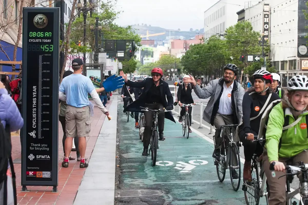 Cyclists riding by an Eco-Display Classic in San Francisco.