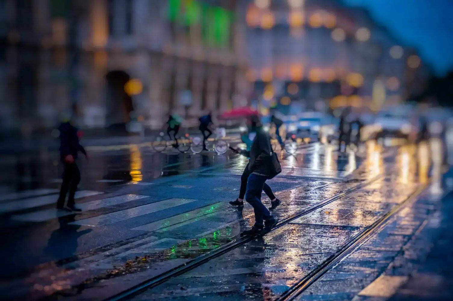 Cyclists and pedestrians in the rain in the city.